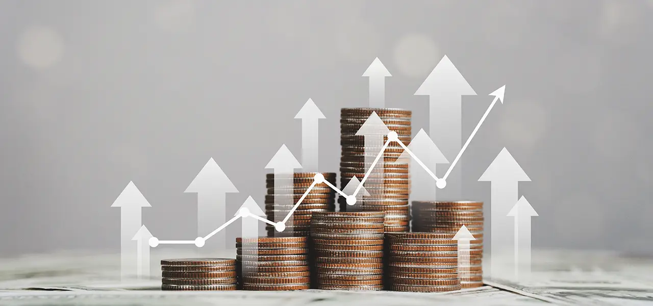 Stapel von Münzen mit aufwärts zeigenden Pfeilen und einem Diagramm. Symbolisiert den Tausenderkontaktpreis.